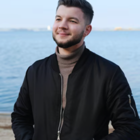 Casual streetwear look with black bomber jacket by the water